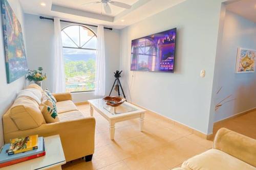 a living room with a couch and a table at Stylish 3-BR Vacation Condo with Scenic Rooftop in Jacó