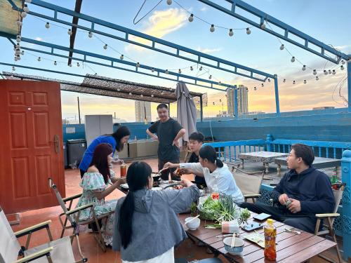 eine Gruppe von Menschen, die auf einem Dach am Tisch sitzen in der Unterkunft 浪子小栈Kashgar Ancient City in Kashgar