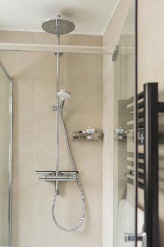 une douche avec pommeau de douche dans une salle de bain dans l'établissement HomyParis, à Paris