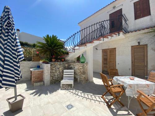 un patio con tavolo, sedie e scala di Villetta mare di Sicilia a Fontane Bianche
