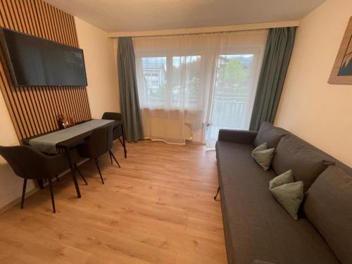 - un salon avec un canapé et une table dans l'établissement Alpha Alpin Apartment, à Zell am See