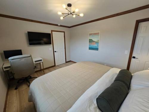 a bedroom with a bed and a desk and a television at Pool Arcade Mtn Views Lake George Home Retreat WFH in Lake George