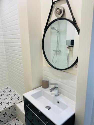 une salle de bain avec un lavabo et un miroir dans l'établissement Charming & cocooning flat - Canal de l’Ourq, à Pantin