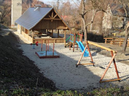 a playground with swings and a small building at Das Lux-Häusla in Kąty Bystrzyckie