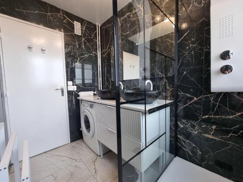 ein Badezimmer mit Waschbecken und Waschmaschine in der Unterkunft Grand appartement 3 chambres Disney - Paris - 82m2 in Neuilly-sur-Marne