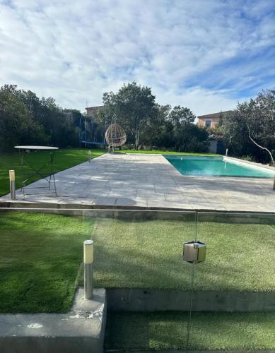 une cour avec une piscine et une aire de jeux dans l'établissement Villa , calme et reposante, à Nîmes