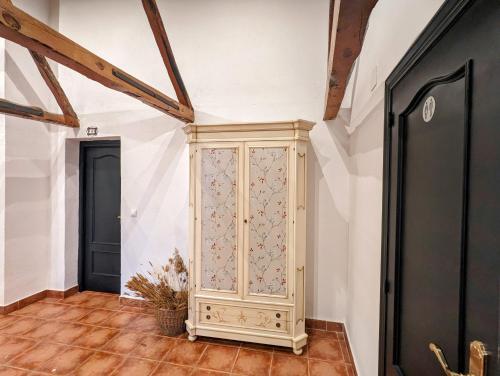 a room with a wooden cabinet in the corner of a room at Alojamiento 13 Jotas in Iniesta