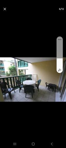d'un balcon avec une table, des bancs et une fenêtre. dans l'établissement T2, 2 étoiles, 5 couchages, piscine, Carcans Maubuisson proche Lacanau, à Carcans