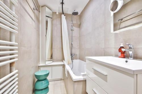 une salle de bain blanche avec un lavabo et des toilettes dans l'établissement Appartement chaleureux au cœur de Montmartre, à Paris