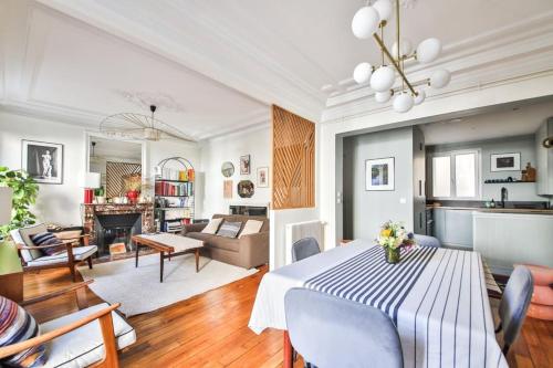 une salle à manger et un salon avec une table et des chaises dans l'établissement Appartement chaleureux au cœur de Montmartre, à Paris