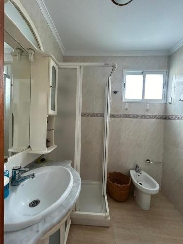 Un baño con ducha, lavabo e inodoro. en Casa Adra, en Adra