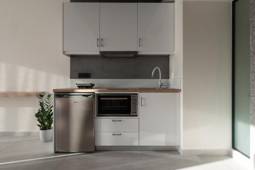 a kitchen with white cabinets and a stainless steel appliance at ENARIA in Nafplio