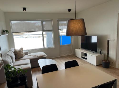 ein Wohnzimmer mit einem Tisch und einem Sofa in der Unterkunft Two bedroom family apartment in Akureyri