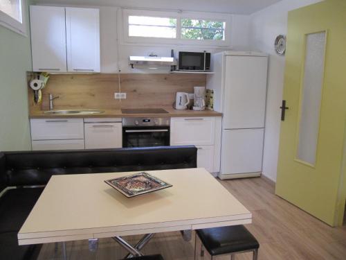 une petite cuisine avec une table et un réfrigérateur dans l'établissement Sur les hauteurs de VENCE, à Vence