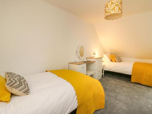 a bedroom with two beds and a mirror at 2 Penporth in Rhayader