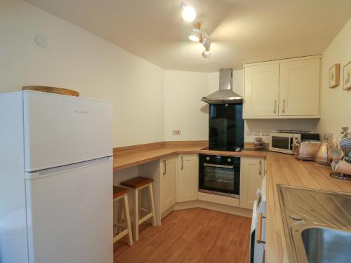 a kitchen with white appliances and a white refrigerator at 1 Penporth in Rhayader