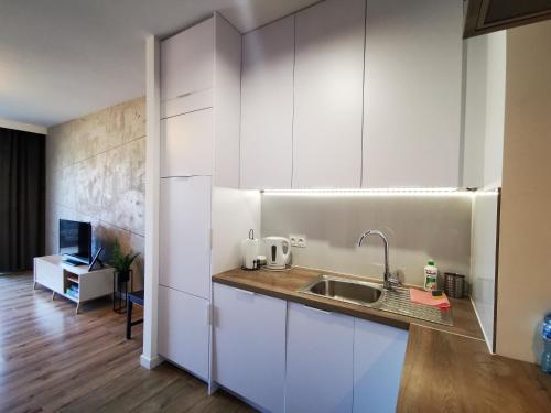 una cocina con armarios blancos y fregadero en Apartament Siedlce, en Siedlce