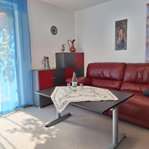 a living room with a red couch and a table at Pension beim Kastell in Sulz am Neckar