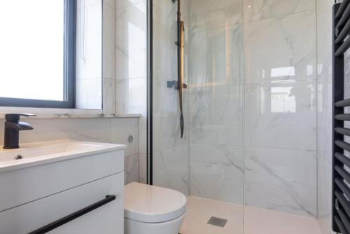 La salle de bains est pourvue d'une douche, de toilettes et d'un lavabo. dans l'établissement Palm Tree House - Candyland, à Orpington