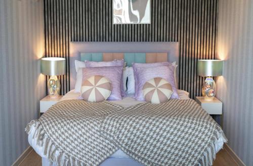 a bedroom with a large bed with two lamps at Palm Tree House - Candyland in Orpington