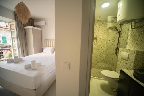 a bedroom with a bed and a bathroom with a toilet at Marco Polo in Petrovac na Moru