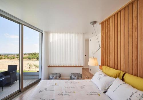 1 dormitorio con cama y ventana grande en Oliveira House - Deluxe Bedrooms, en Castelo Novo