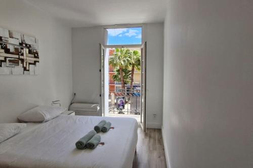 - une chambre avec un grand lit blanc et 2 paires de serviettes dans l'établissement Notre cœur de ville douillet, à Sète