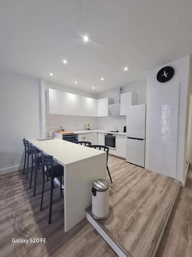 - une cuisine blanche avec une table et des chaises dans l'établissement Notre cœur de ville douillet, à Sète