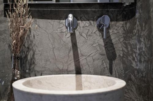 a sink with two faucets in a bathroom at Agapitos Villas & Guesthouses in Agios Ioannis Pelio