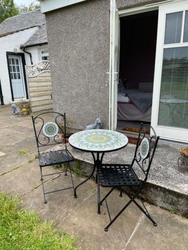 a table and two chairs sitting on a patio at Ben Lomond Cottage in Gartocharn