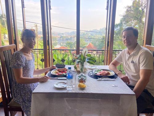 un hombre y una mujer sentados en una mesa con comida en Sesatha lake Kandy, en Kandy