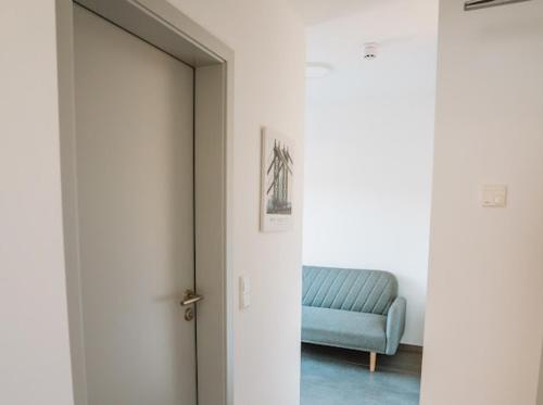 a room with a blue couch and a door at Mey Boardinghouse in Bielefeld