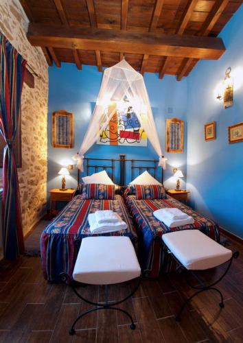 two beds in a room with blue walls at CASA RURAL SANDRA in La Carrera