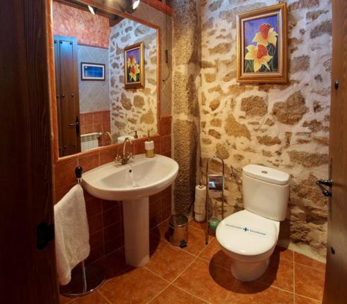 a bathroom with a white toilet and a sink at CASA RURAL SANDRA in La Carrera