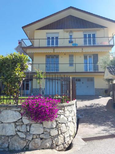 a large house with a stone wall and purple flowers at La Pineta, 26 - 3 in Casarza Ligure
