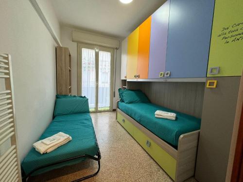 a room with two beds and a rainbow wall at Casa Ponte Romano in Faenza