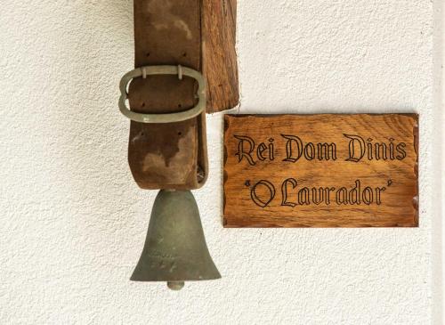 a wooden sign on a wall with a metal object at Reinado de Dom Dinis in Dornes