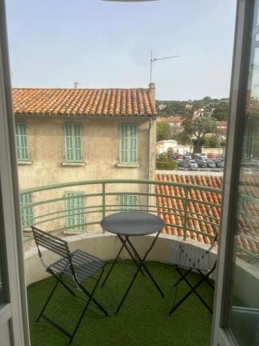 einen Tisch und einen Stuhl auf einem Balkon mit Aussicht in der Unterkunft Appartement centre du village in Cassis