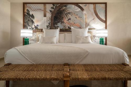 a bedroom with a large white bed with two lamps at Hotel Ritual de Terra & SPA Moraira in Moraira