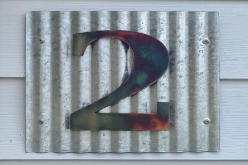 a metal sign with a large number on a building at Lake Huron - Super Cute Lake Front Cabin (Sleeps 5) in Oscoda