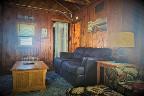 a living room with a couch and a table at Lake Huron - Super Cute Lake Front Cabin (Sleeps 5) in Oscoda