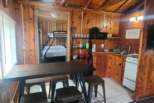 a kitchen with a table and chairs in a cabin at Lake Huron - Super Cute Lake Front Cabin (Sleeps 5) in Oscoda