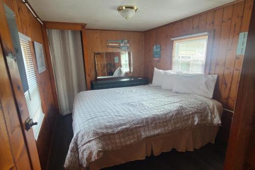Schlafzimmer mit einem Bett und einem Spiegel in der Unterkunft Lake Huron - Super Cute Lake Front Cabin (Sleeps 5) in Oscoda