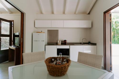 eine Küche mit einem Glastisch mit einem Korb darauf in der Unterkunft Habitation TABANON in Petit-Bourg
