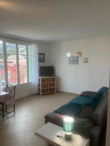 ein Wohnzimmer mit einem Sofa und einem Tisch in der Unterkunft Appartement centre du village in Cassis
