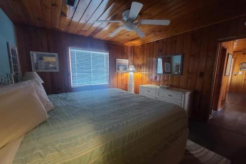 1 dormitorio con 1 cama y ventilador de techo en Lake Huron - 3 Bedroom, 2 Bath Lake Front Home (Sleeps 12), en Oscoda