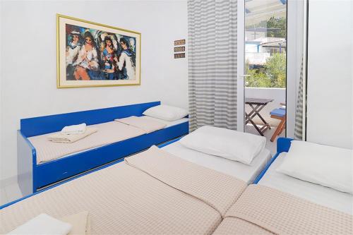 une chambre avec deux lits et une fenêtre dans l'établissement Feni Traditional House Loutra 2 bedrooms 6 guests, à Agia Paraskevi