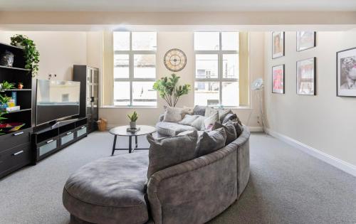 a living room with a couch and a tv at Beautiful 2 Bed Apartment just steps to the Beach in Weymouth