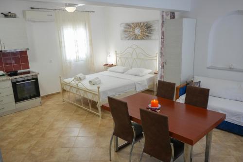 a bedroom with a bed and a table and a kitchen at Avlemonas Guest House in Avlemonas