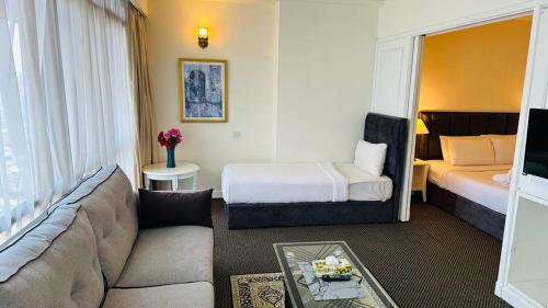 een woonkamer met een bank en een bed bij Sunset service suite At Times square in Kuala Lumpur